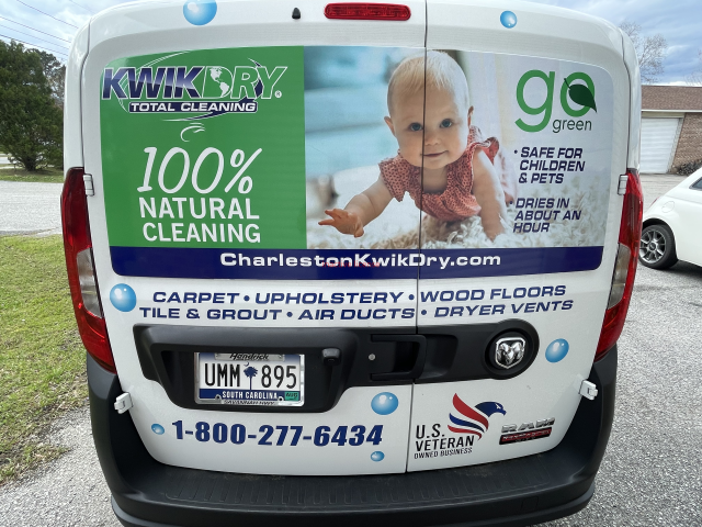 Branded cleaning van with large green “100% natural cleaning” advertisement on the rear door.