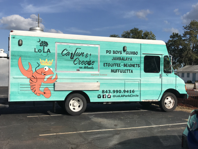 Mint-green food truck with a cartoon lobster and “Captain Crews” seafood/catering text in a parking lot