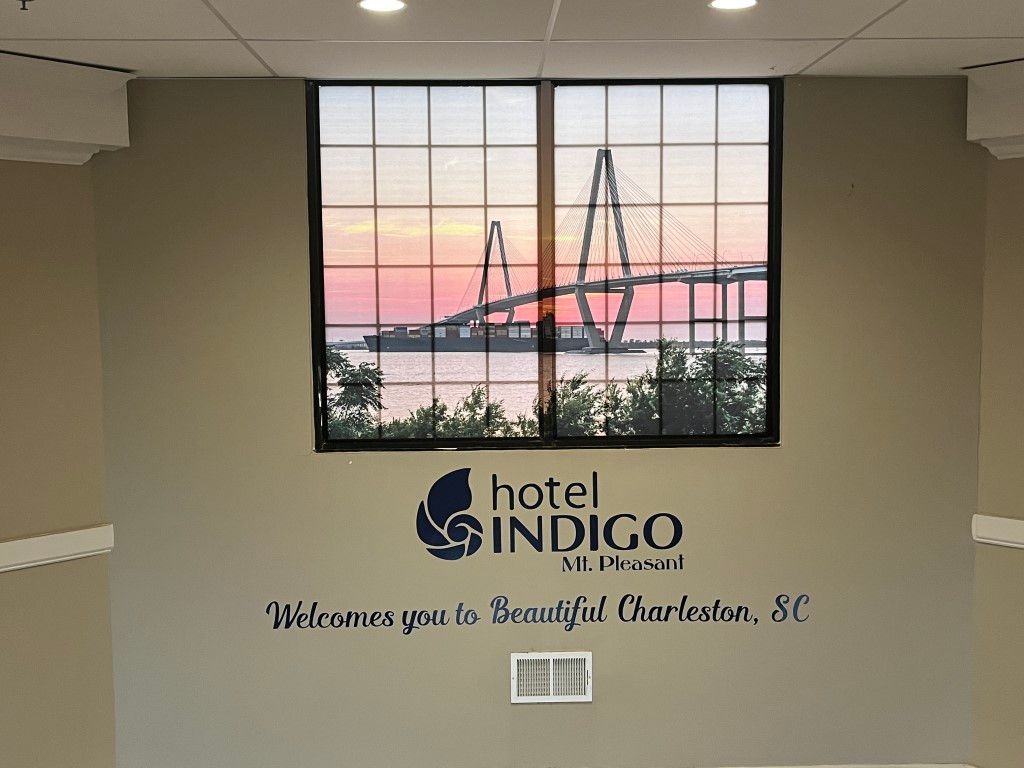 Hotel Indigo Myrtle Beach wall sign with sunset harbor photo and “Welcome to Beautiful Port Royal, SC” text