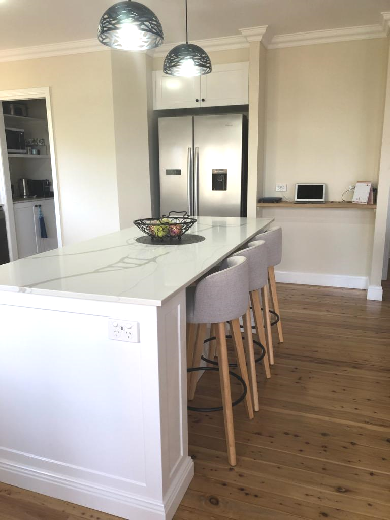 Modern Kitchen With White Island, Stainless Steel Fridge, and Light Wood Floors — Payton Kitchens in St George, QLD
