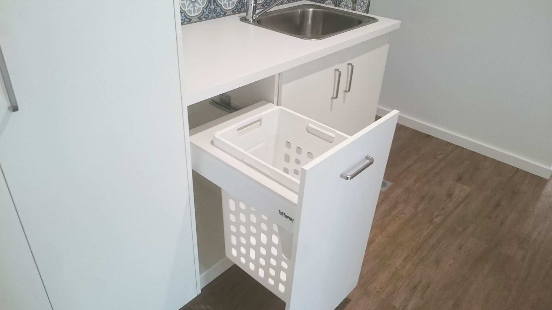 Laundry Room With a Pull-out Cabinet Holding a White Laundry Basket — Payton Kitchens in Crows Nest, QLD