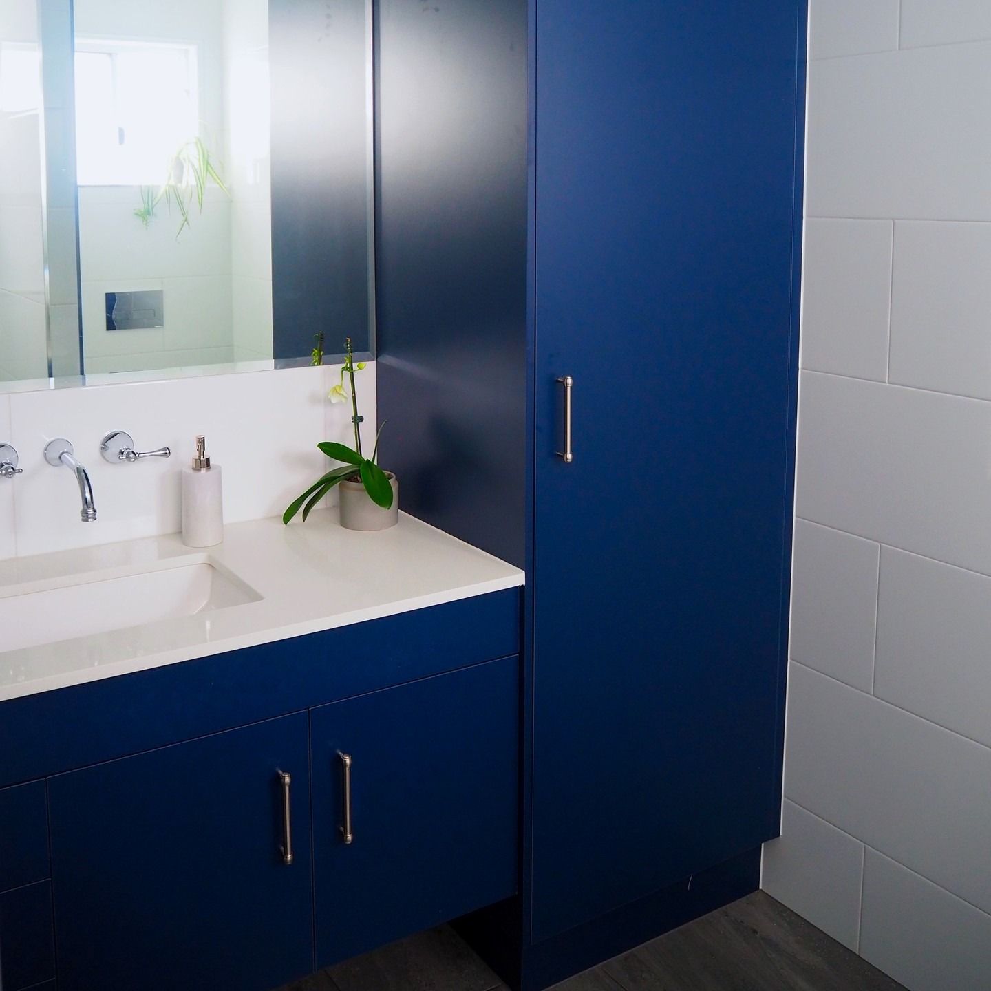 Blue Bathroom Vanity With Tall Storage Cabinet, White Countertop, and White Tile — Payton Kitchens In Wilsonton, QLD