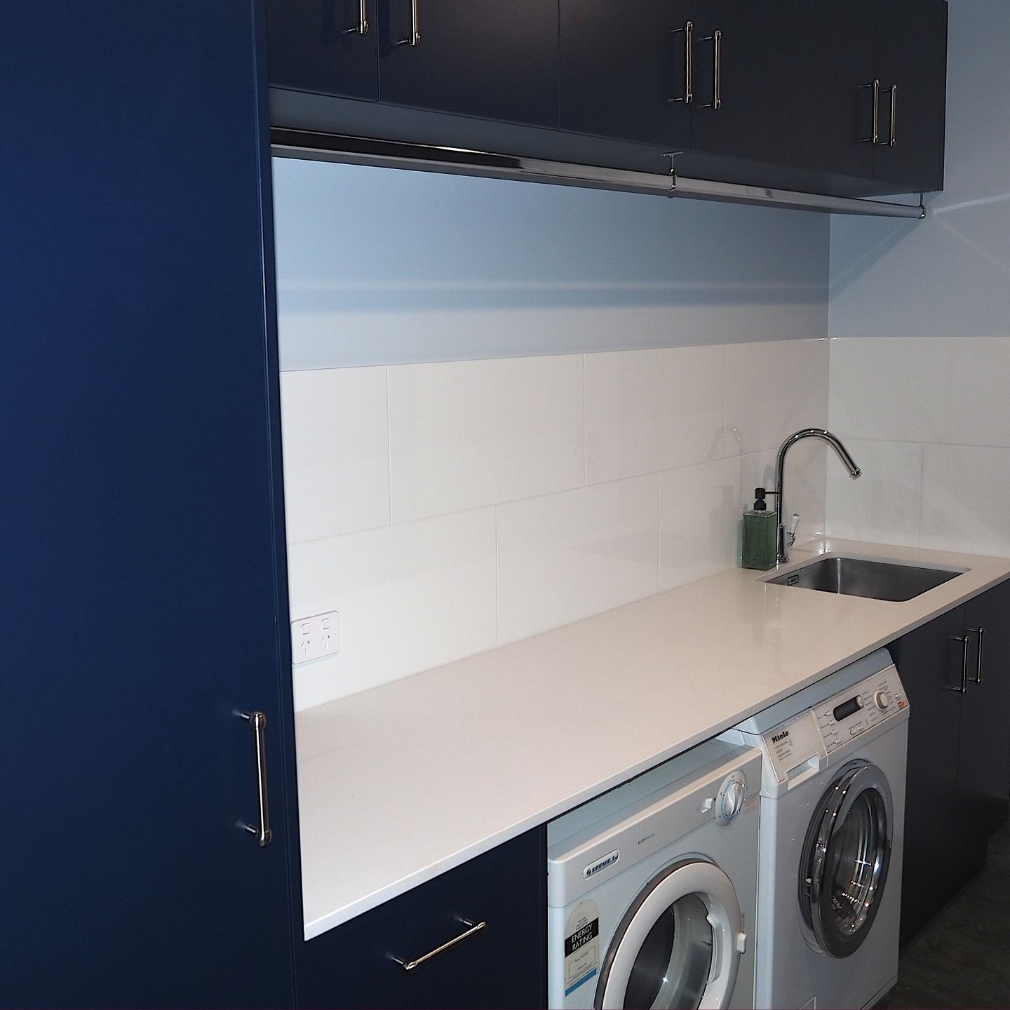 Laundry Room With Blue Cabinets, Sink, Washing Machines, and White Backsplash — Payton Kitchens in Dalby, QLD