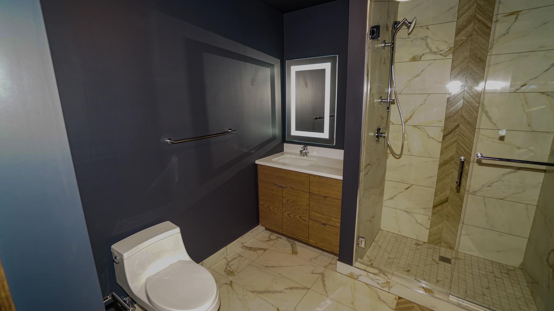 A bathroom with a toilet , sink , and walk in shower.