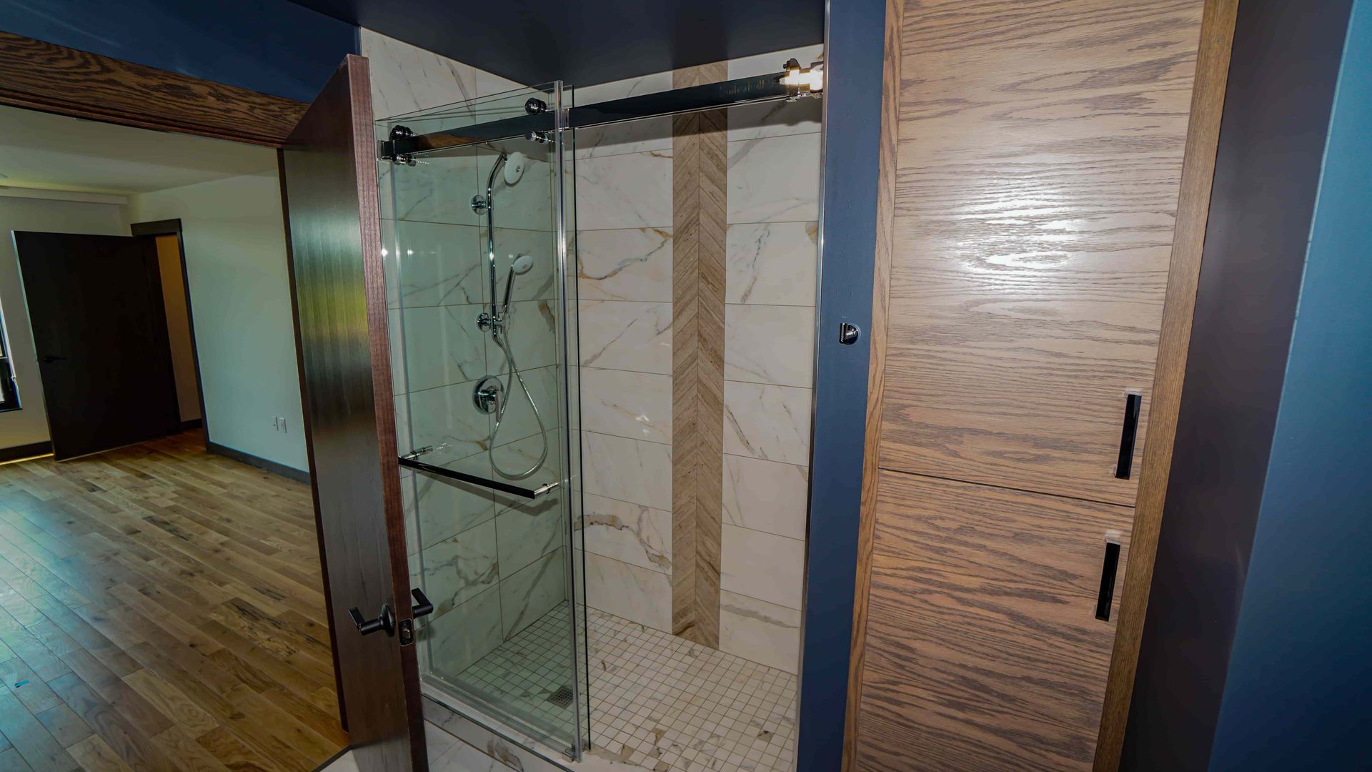 A bathroom with a walk in shower and a sliding glass door.