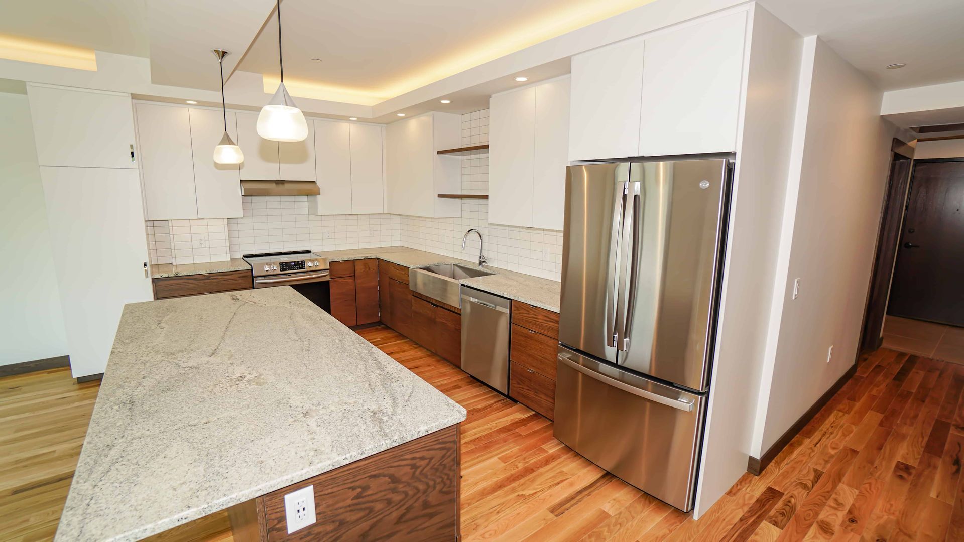 A kitchen with stainless steel appliances and granite counter tops.