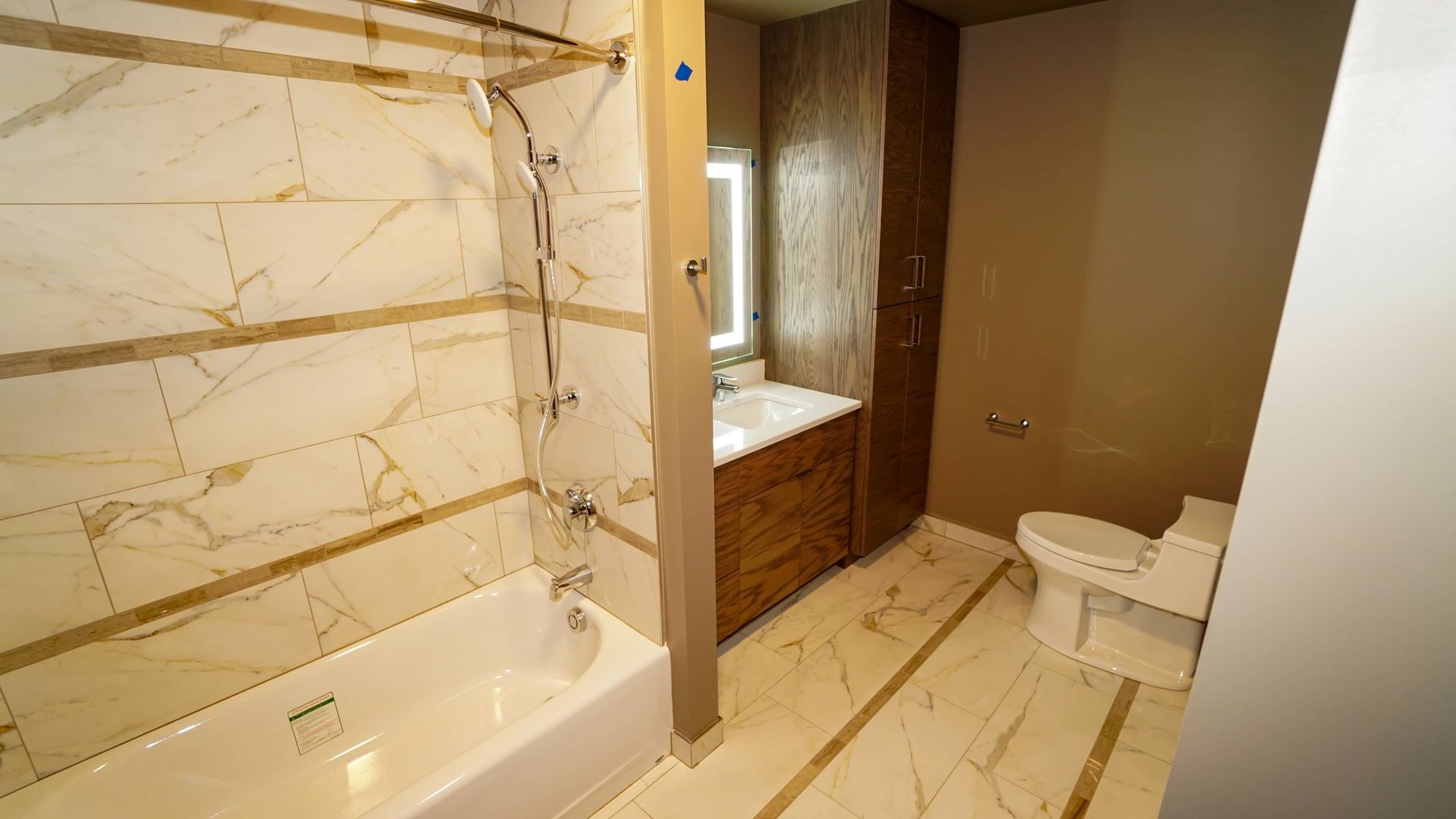 A bathroom with a tub , toilet , sink and shower.