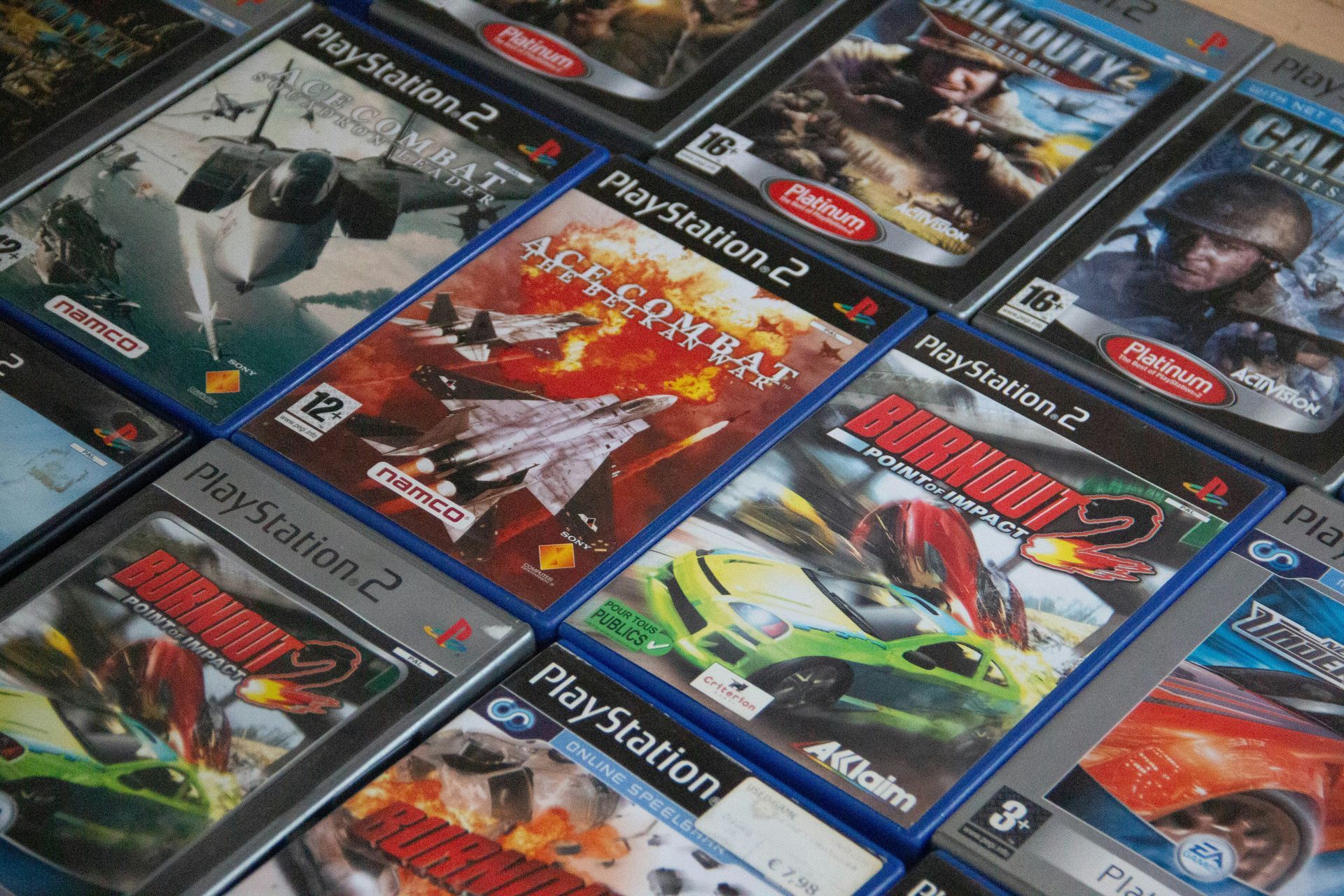Assorted PlayStation 2 game cases displayed in a colorful, overlapping stack.