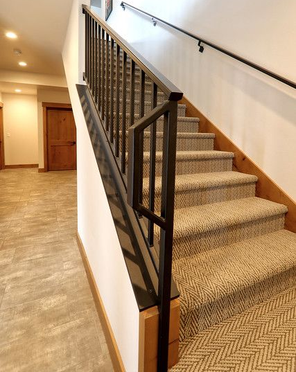 Staircase with metal railing and carpeted steps in a modern interior.