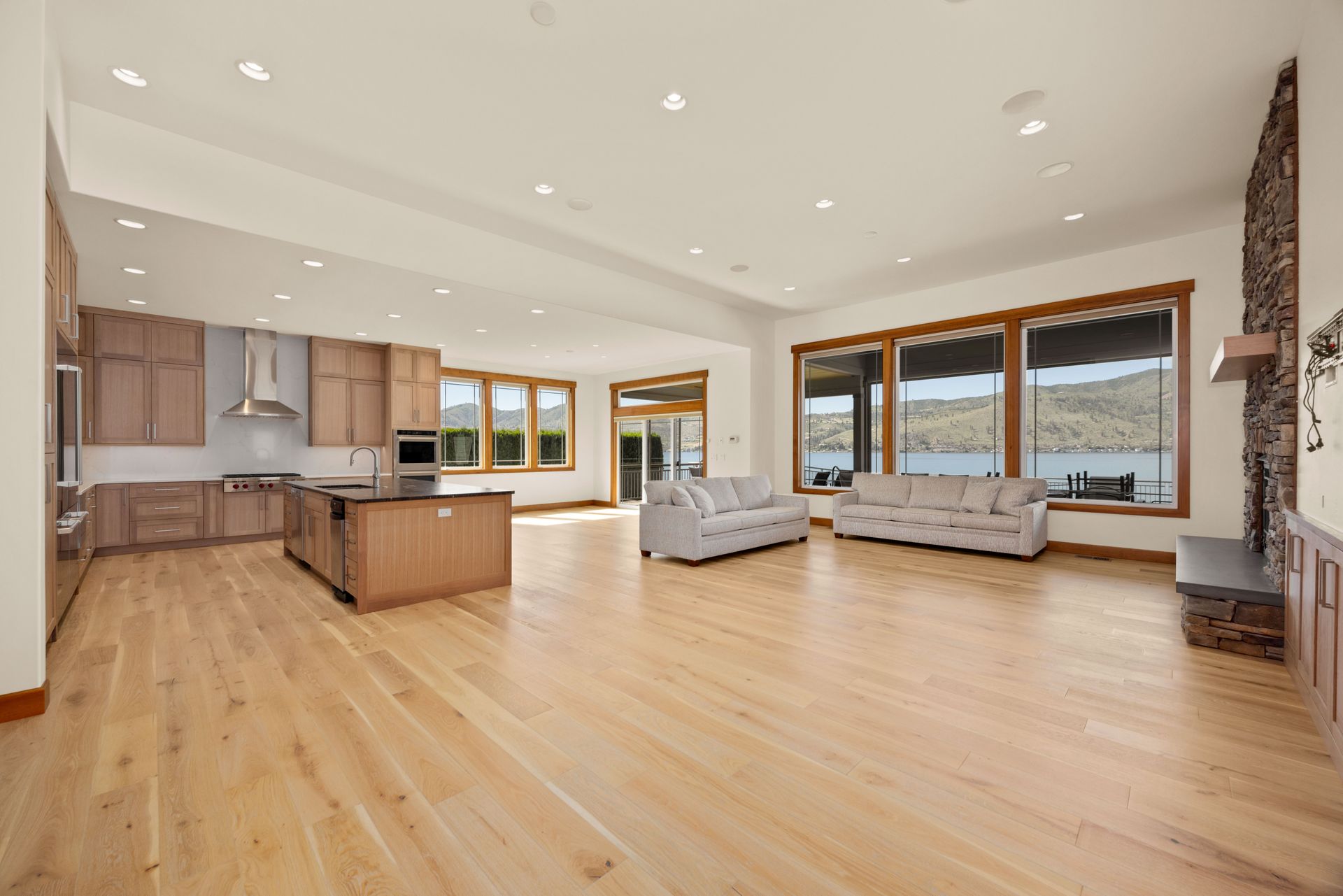 Spacious open-concept kitchen and living area with hardwood floors and lake views.