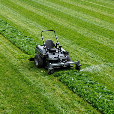 Riding lawn mower cutting striped grass on a green field
