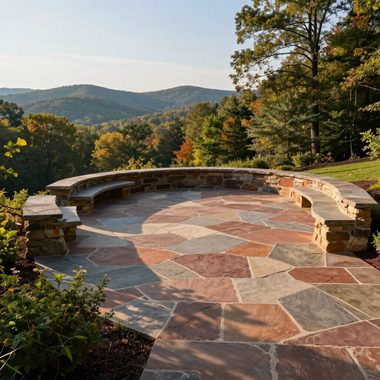 Stone patio overlook with curved bench and autumn trees, facing layered mountains in warm sunlight