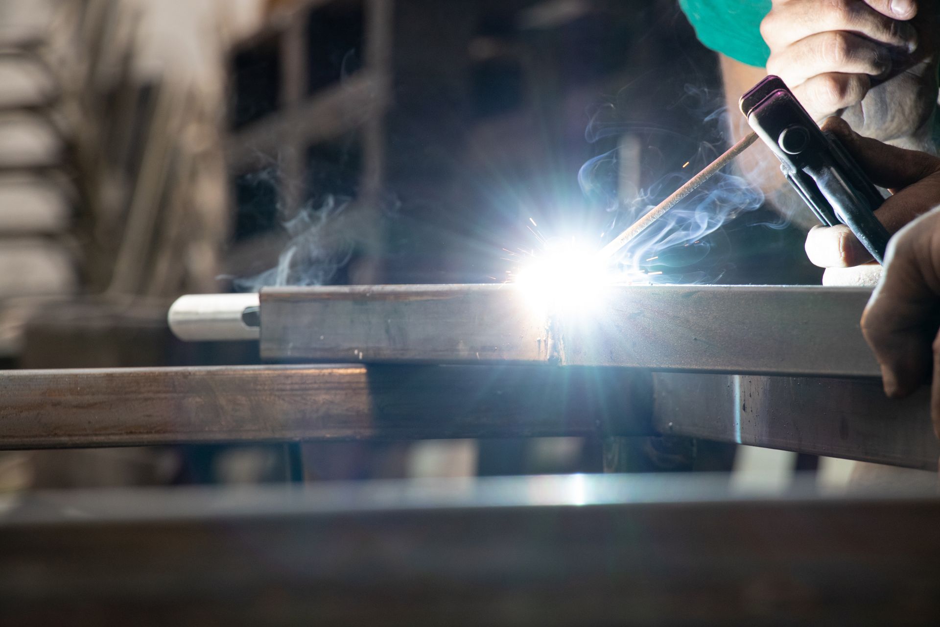Aluminum Fabrication A man is welding a piece of metal.