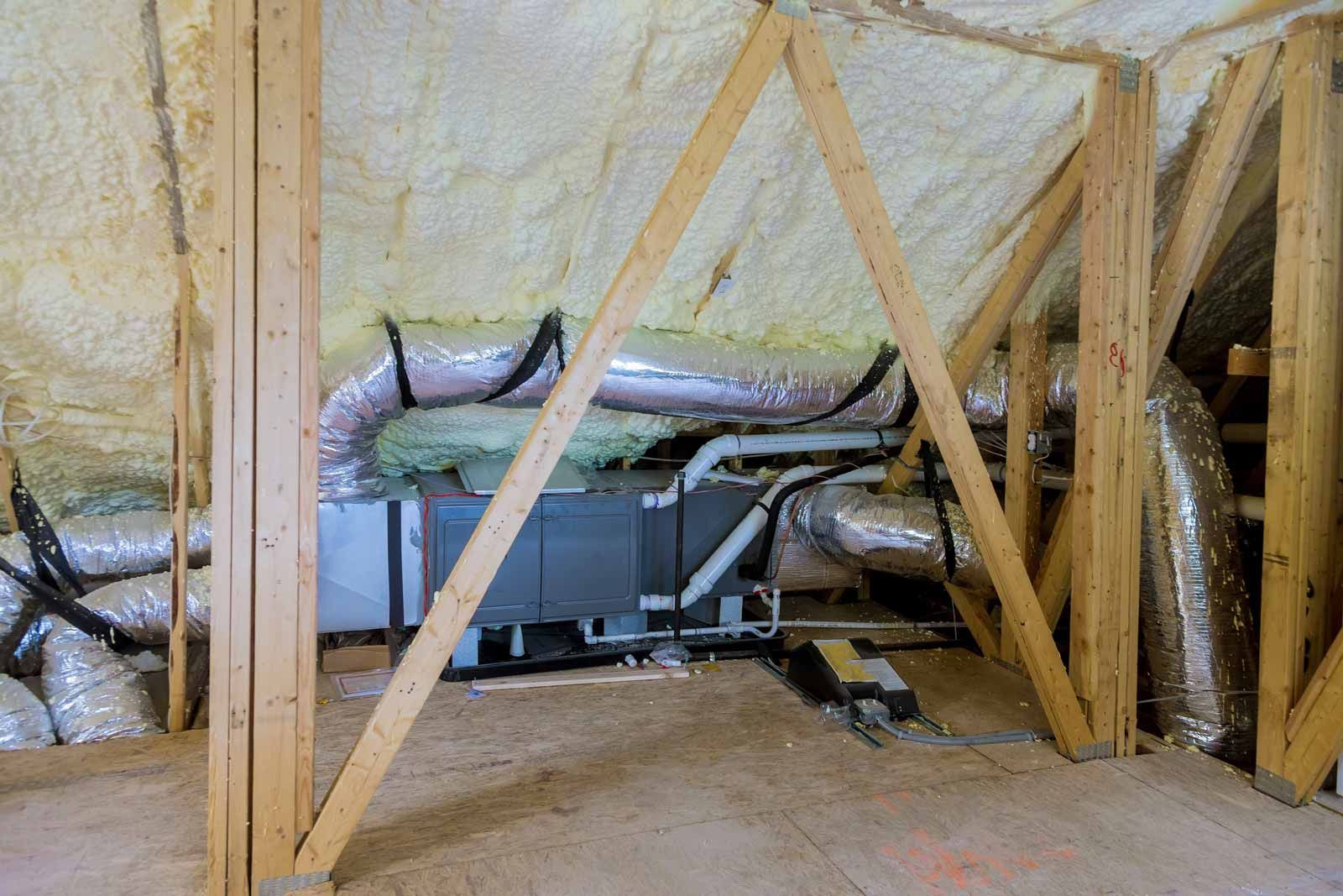 Insulated attic with HVAC unit, ducts, and wooden framing braces