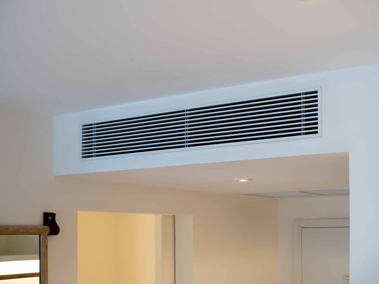 White wall air vent above a doorway in a home interior