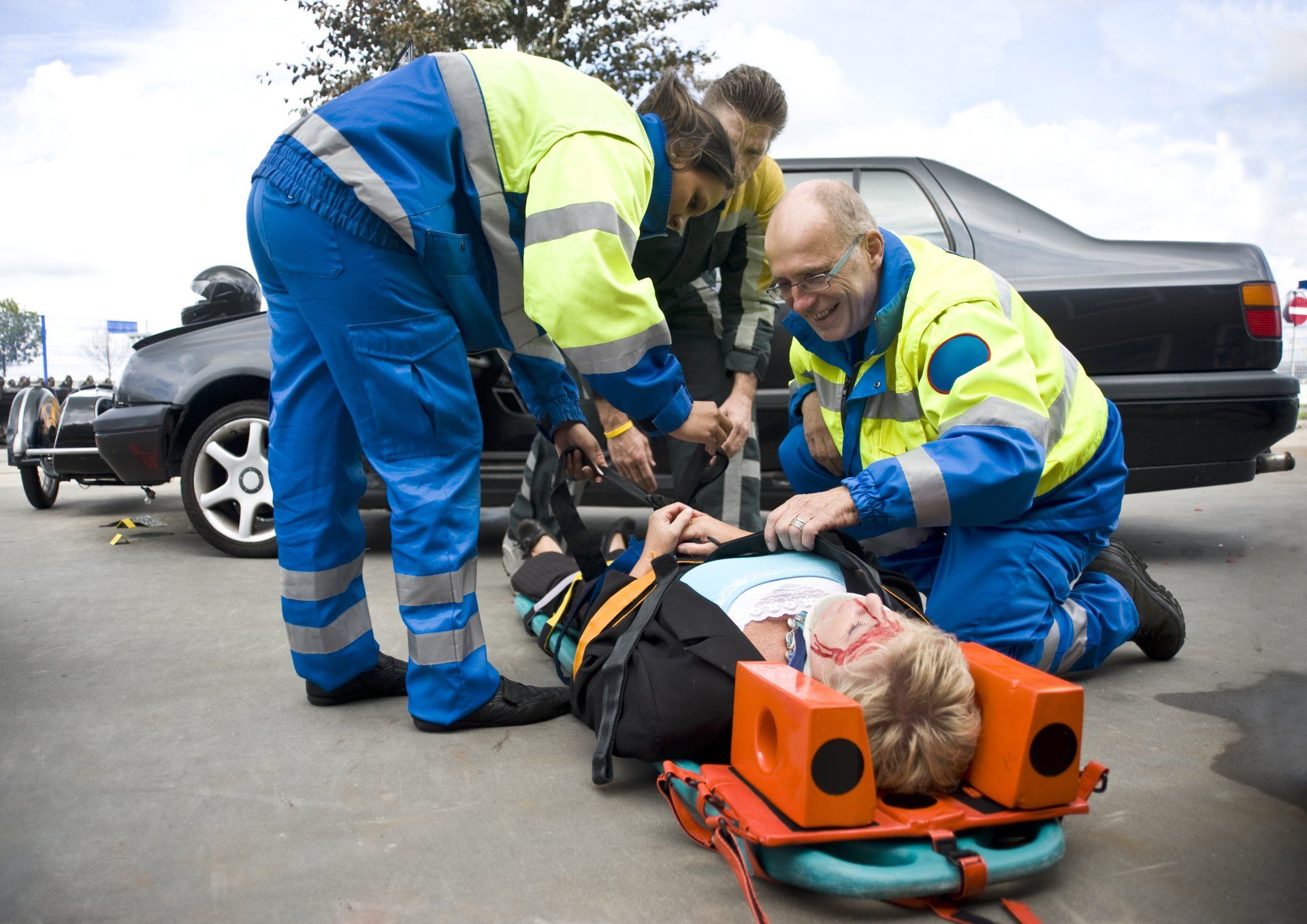 A group of paramedics are helping a person who is laying on a stretcher.