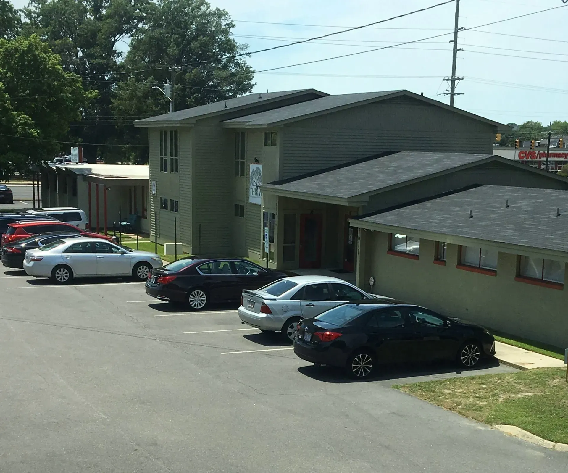 A row of cars are parked in front of a building
