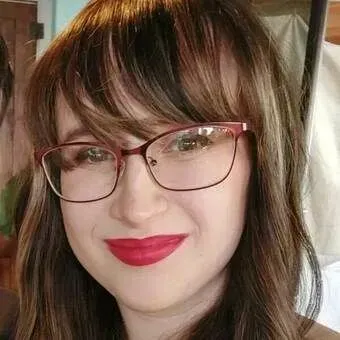 A close up of a woman wearing glasses and red lipstick.