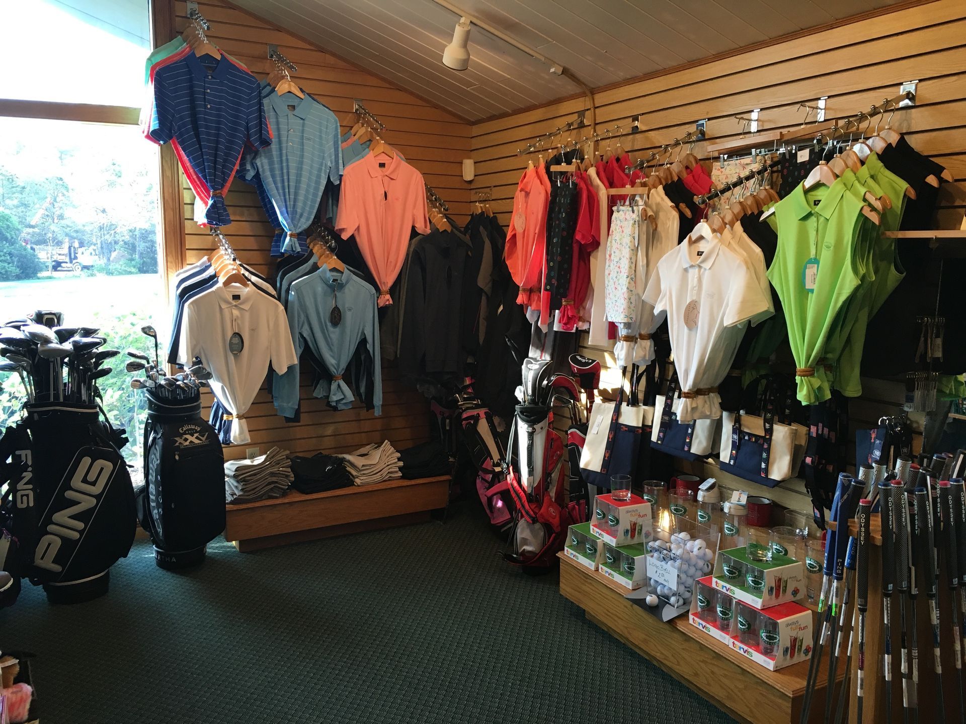 Golf shop interior with golf apparel, clubs, and accessories for sale.