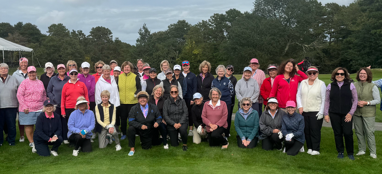 A group of people are posing for a picture on a golf course.