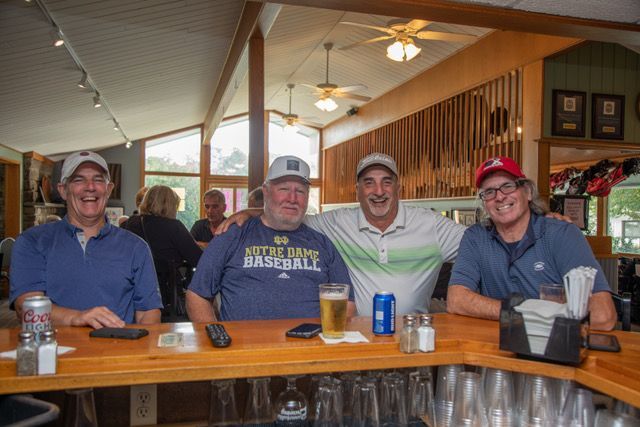 A group of men are posing for a picture at a bar.