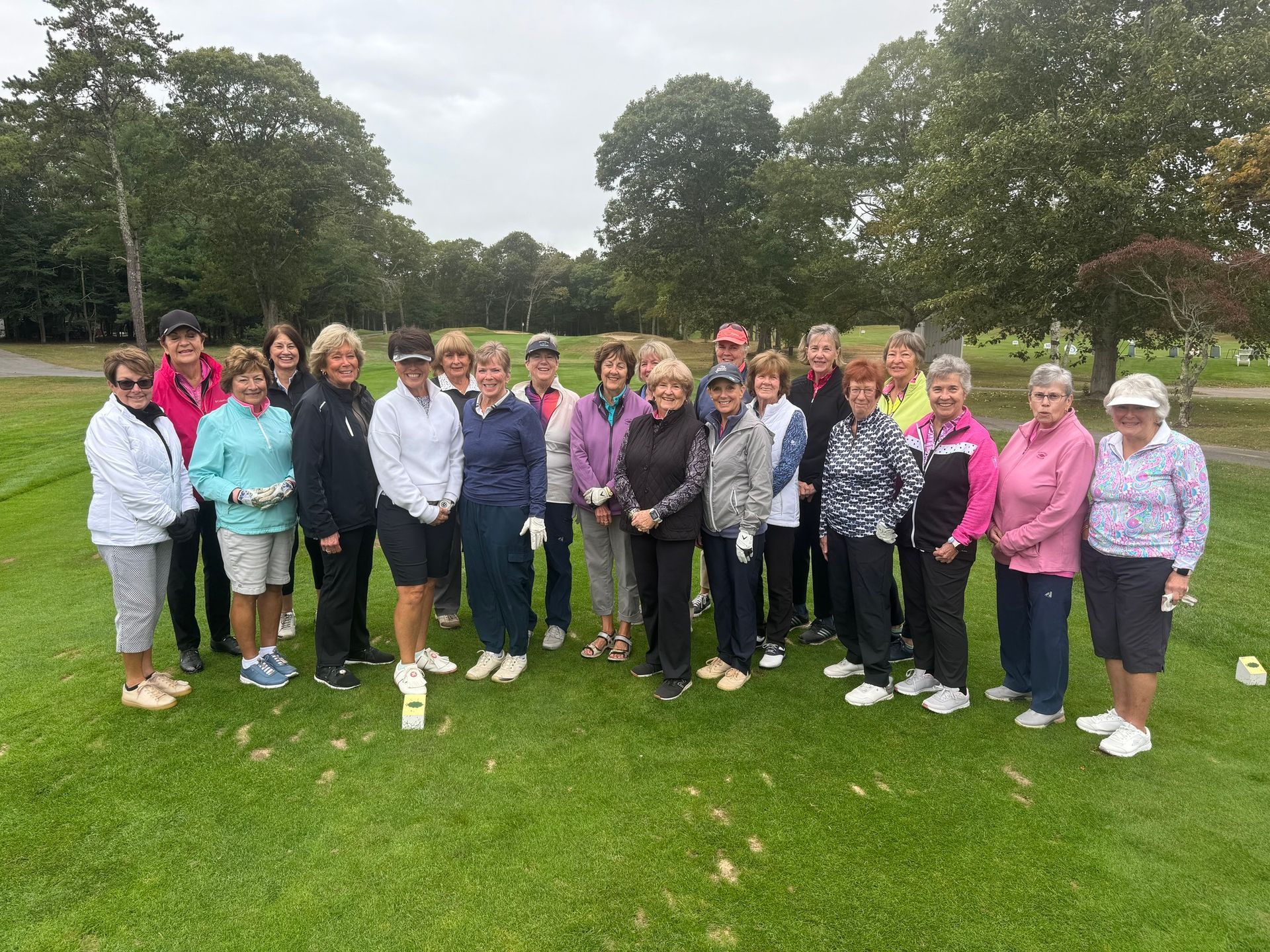 A group of women are posing for a picture on a golf course.
