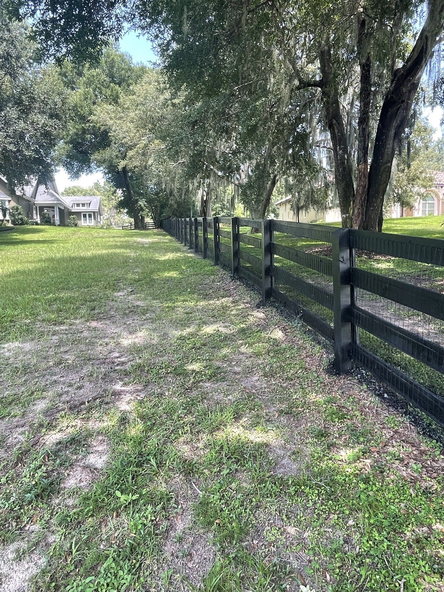 big backyard with black wooden fence