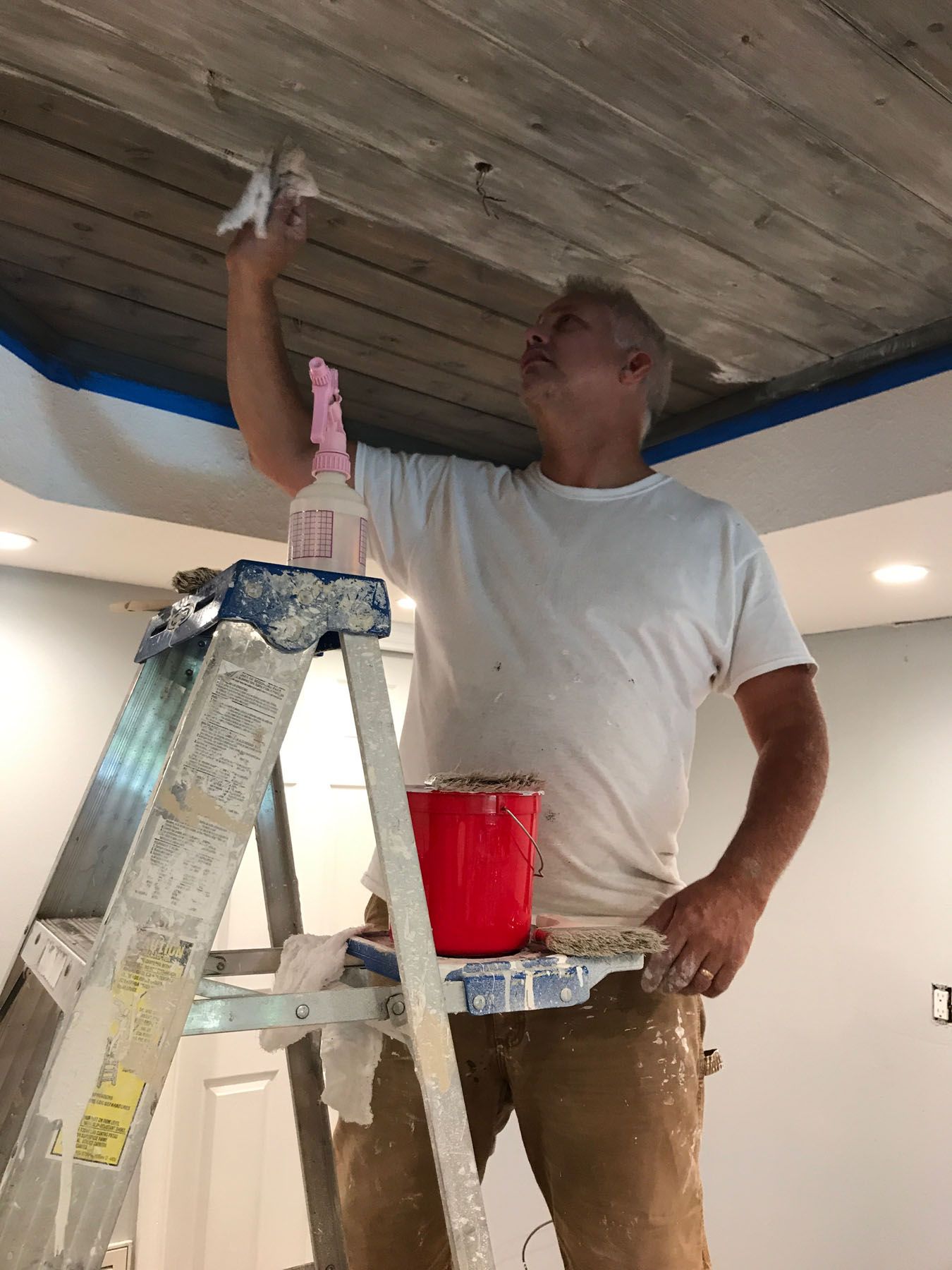 man working on a new paint of house ceiling