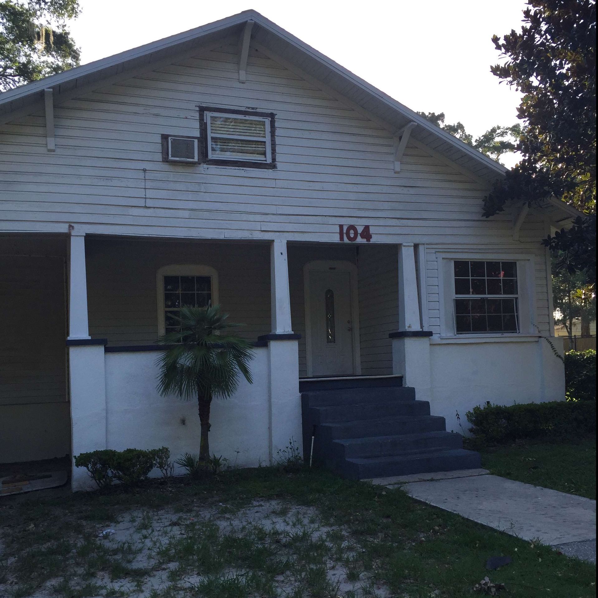 exterior view of a residential house with old white paint
