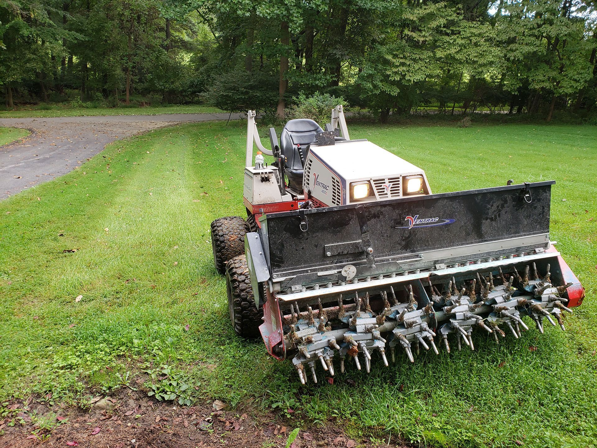A lawn mower is sitting on top of a lush green lawn.