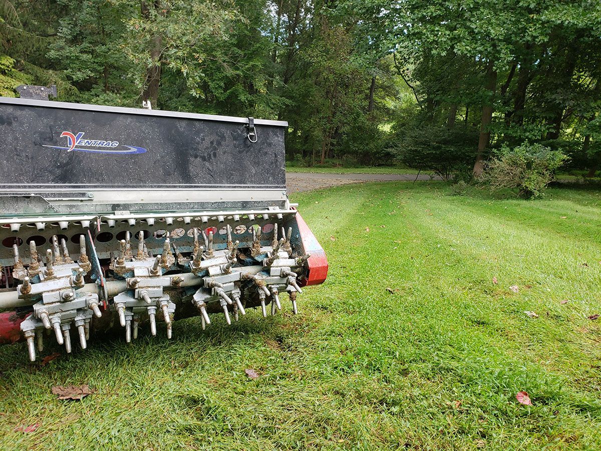 A lawn mower is parked in the middle of a lush green field.
