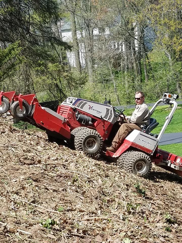 A man is riding a tractor down a hill.
