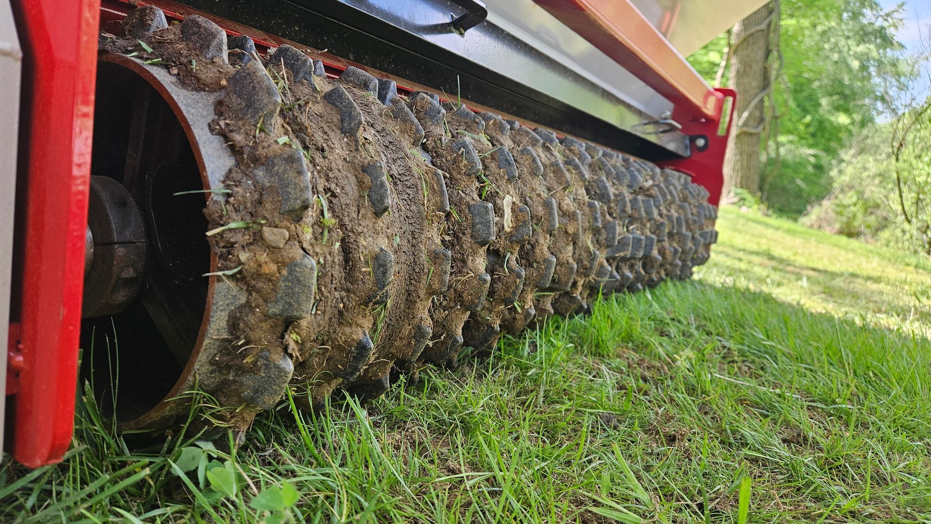 A close up of a machine cutting grass on a lush green field.