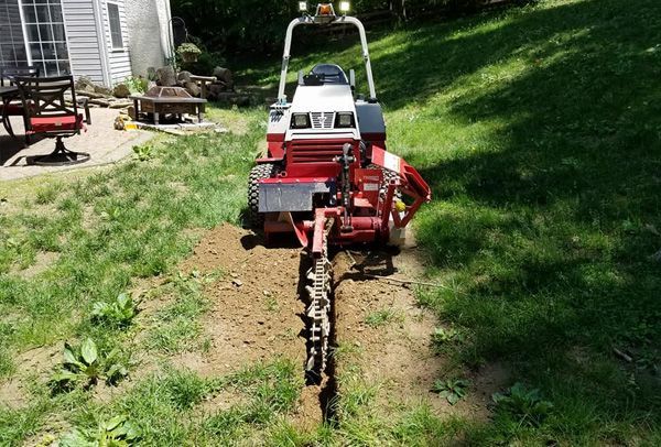 A red and white tractor is parked in a grassy yard.