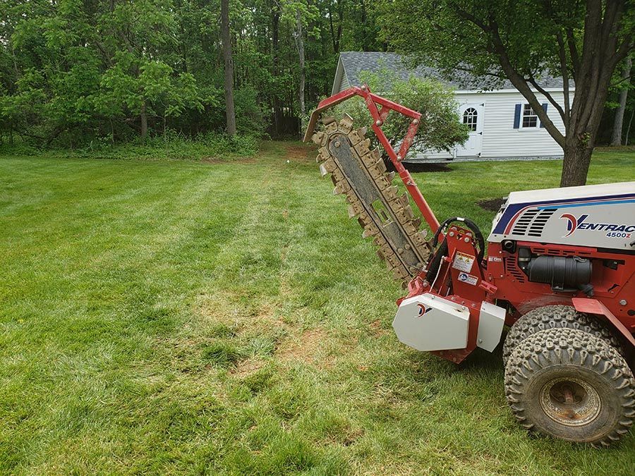 A red and white tractor is parked in a grassy yard.