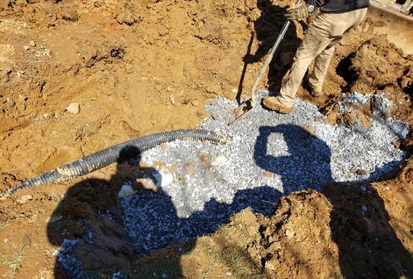 A man is digging in the dirt with a shovel.