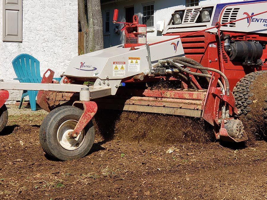 A red and white tractor is parked in front of a house.