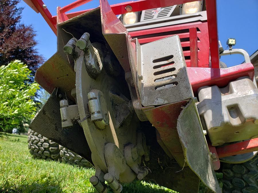 A red and gray tractor is parked in a grassy field.