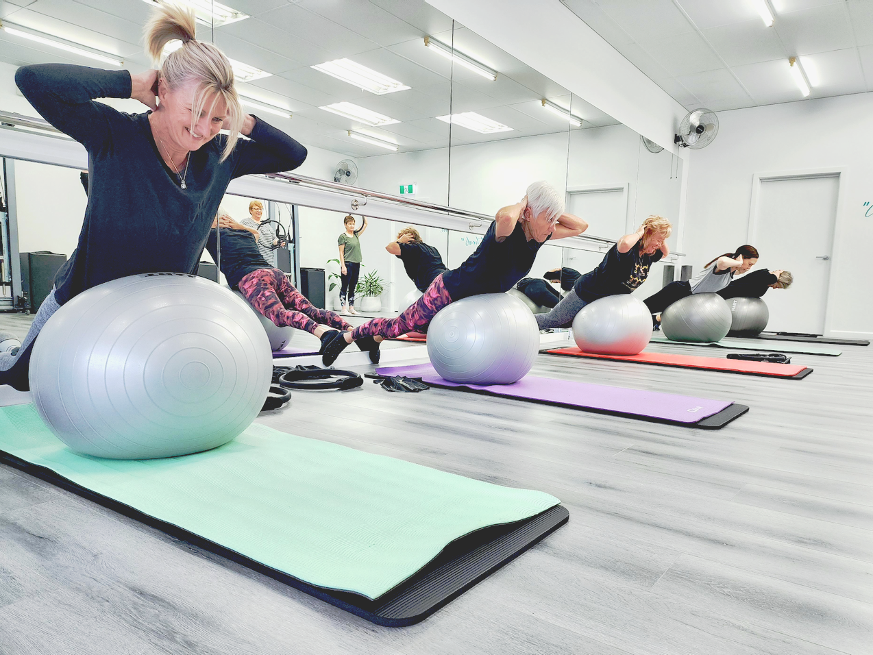 women with Pilates Balls in a matwork class