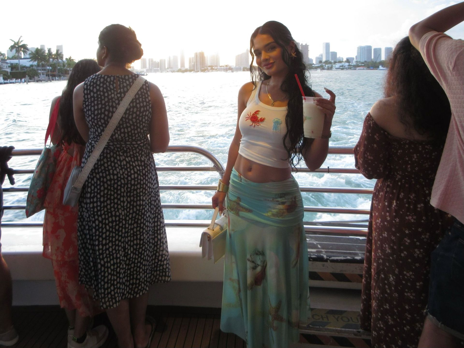 Passenger with the Miami Skyline in the background enjoying the Views and drinks of a Bayside Star island Cruise 