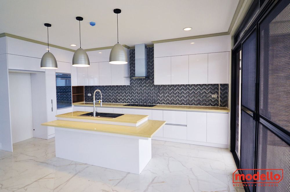 A Kitchen With White Cabinets And A Large Island In The Middle — ModulPlus in Hervey Bay, QLD