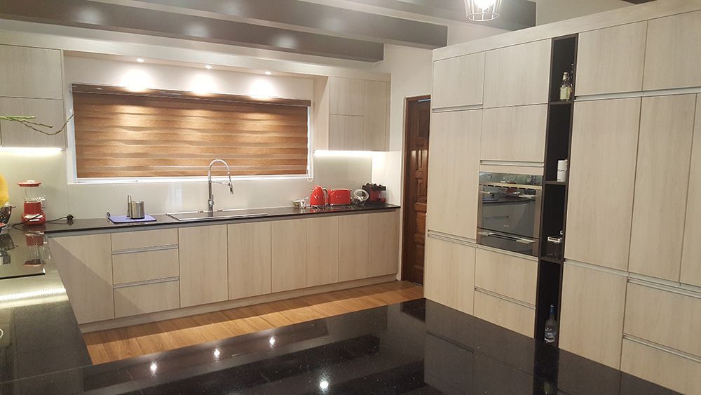 A Kitchen With Lots Of Cabinets And A Black Counter Top — ModulPlus in Hervey Bay, QLD