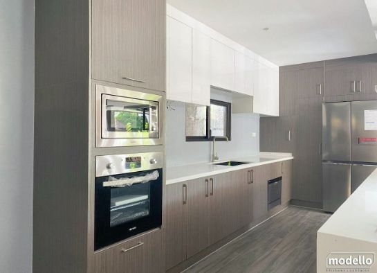 A Kitchen With Stainless Steel Appliances and Wooden Cabinets — ModulPlus in Hervey Bay, QLD