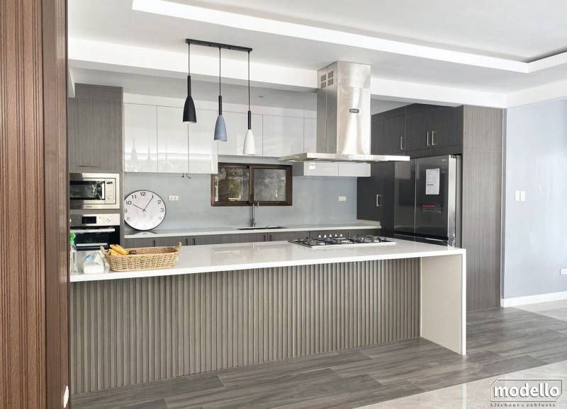 A Kitchen With A Large Island And A Clock On The Wall — ModulPlus in Hervey Bay, QLD
