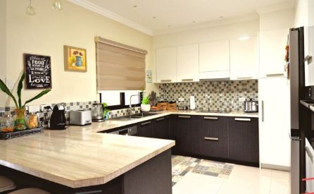 A Kitchen With Black Cabinets, a Granite Counter Top, a Refrigerator, and a Sink — ModulPlus in Hervey Bay, QLD