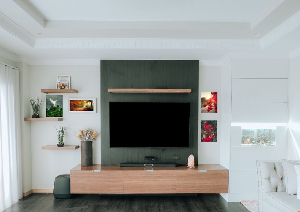 A Living Room With A Flat Screen Tv Mounted On The Wall — ModulPlus in Hervey Bay, QLD