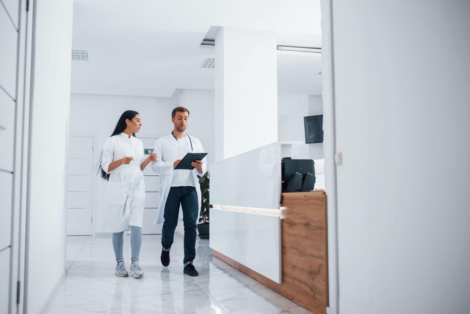 Medical professionals discussing patient care in clinic hallway