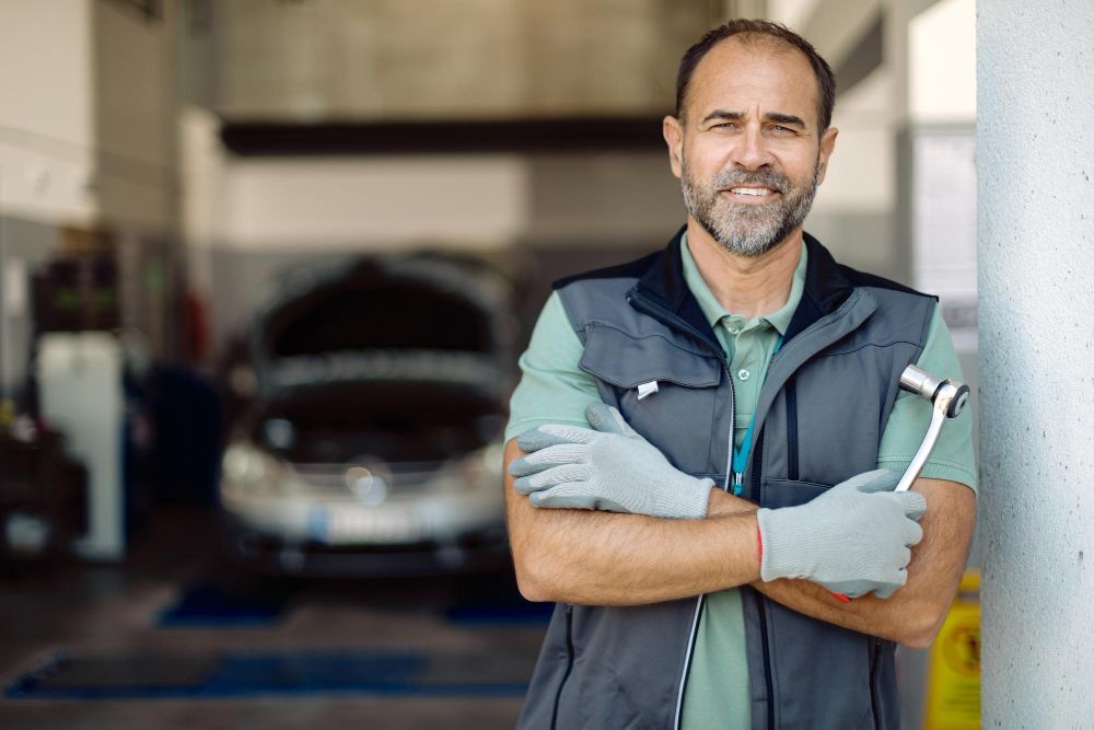Auto repair technician standing confidently in workshop