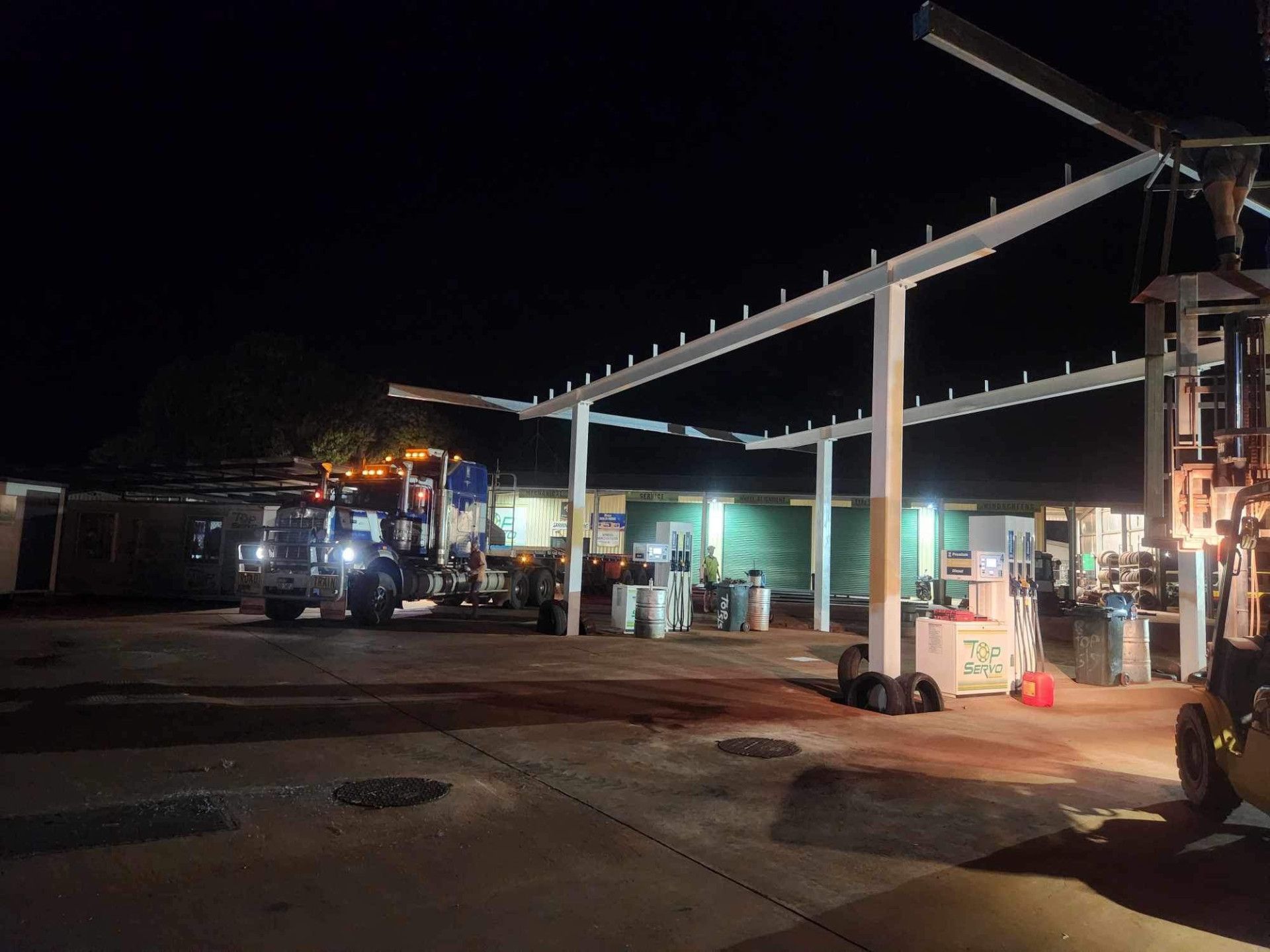 A Gas Station Canopy is Being Installed at Night — Lincoln Fabrication in Miles End, QLD