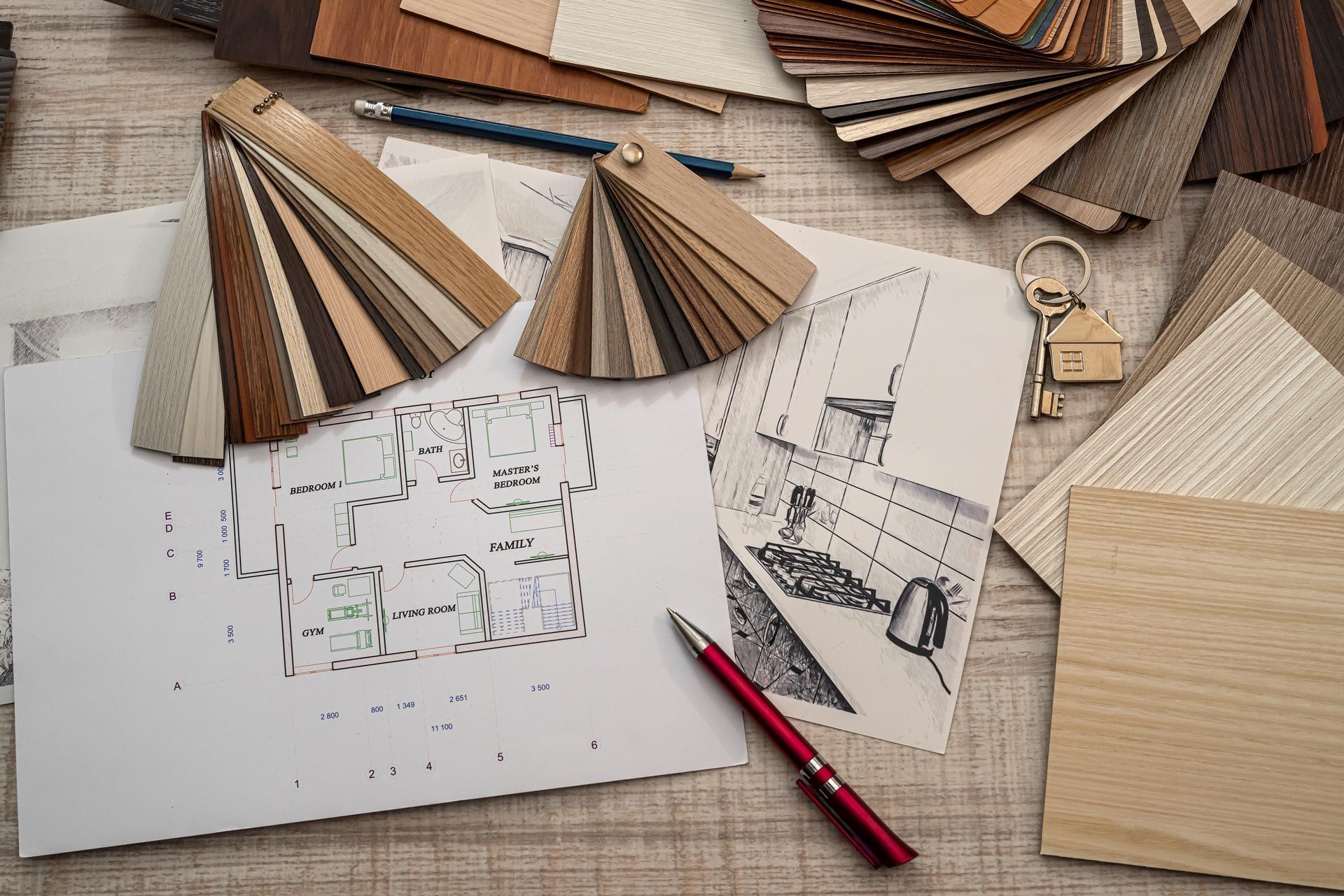 Architectural design workspace with wood samples, sketches, and red pencil on a desk.